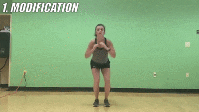 woman demonstrating modified in-and-out squat jumps