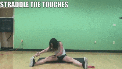 woman demonstrating straddle toe touches