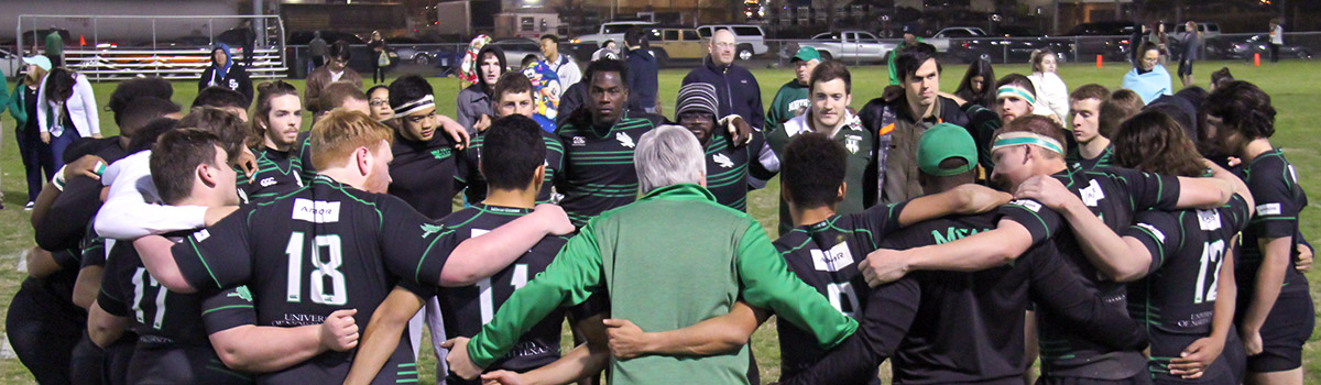 A sports club team is held in a huddle.