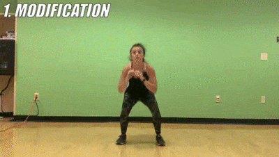 woman demonstrating modified jump squat + knee touch