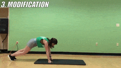 woman demonstrating modified 2 mountain climber + 2 plank taps