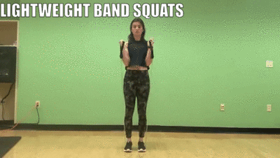 woman demonstrating lightweight band squats