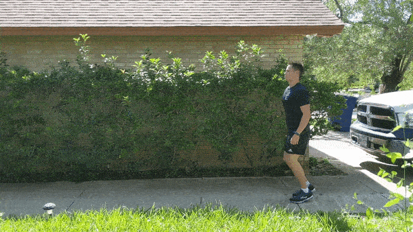 male demonstrating high knee warmup jog