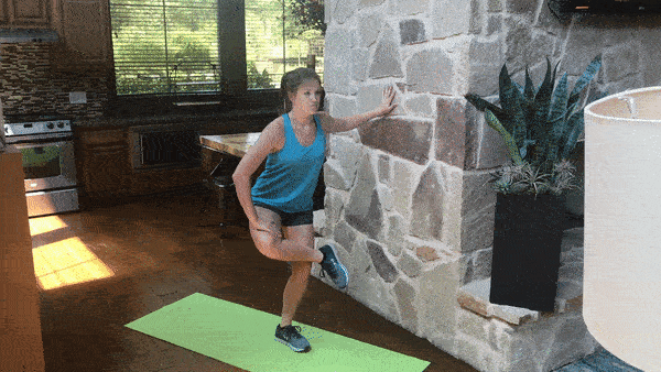 female demonstrating standing glute stretch