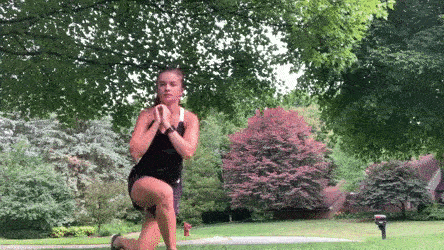 woman demonstrating curtsy to jump squat modification