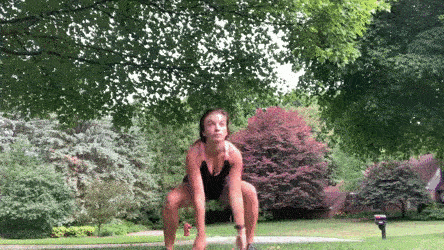 female demonstrating squat to side reach