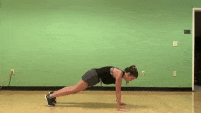 female demonstrating modified plank push + opposite knee tap