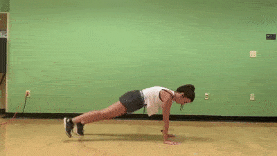 female demonstrating modified in out planks
