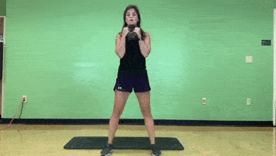 female demonstrating squat + pulse
