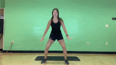 female demonstrating high low jack to squat